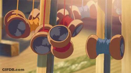 A Bunch Of Spools Of Thread Hanging From A Fence GIF