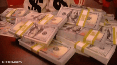 A Bunch Of Stacks Of Money On A Table GIF