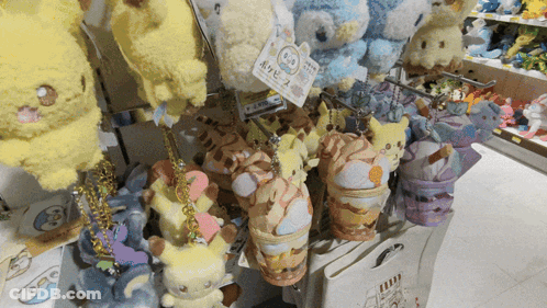 A Bunch Of Stuffed Animals Are Hanging On A Shelf With A Tag That Says ' Pokemon ' On It GIF