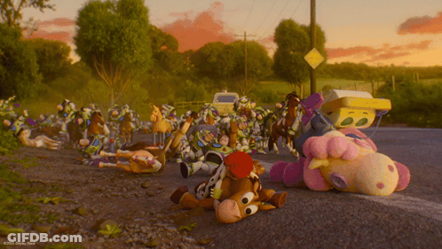 A Bunch Of Stuffed Animals Are Laying On The Side Of A Road GIF