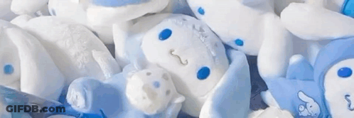 A Bunch Of Stuffed Animals Laying On Top Of Each Other . GIF