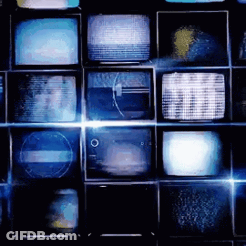 A Bunch Of Televisions Are Stacked On Top Of Each Other On A Wall GIF