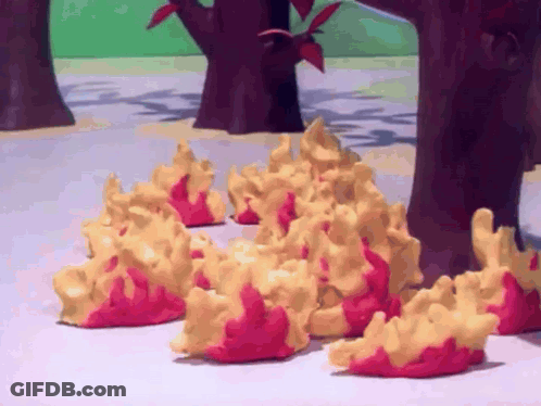 A Bunch Of Yellow And Red Objects Are Sitting On A Table In Front Of Trees GIF