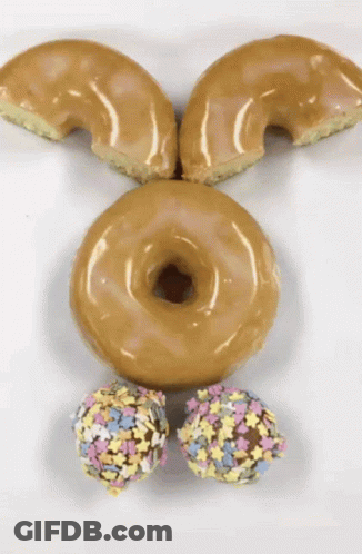 A Bunny Face Made Out Of Donuts And Sprinkles On A White Surface GIF