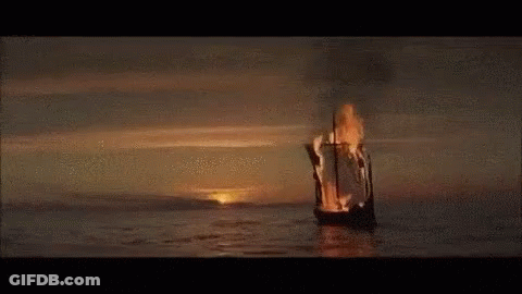 A Burning Boat Is Floating On Top Of A Body Of Water . GIF