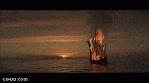 A Burning Boat Is Floating On Top Of A Body Of Water . GIF