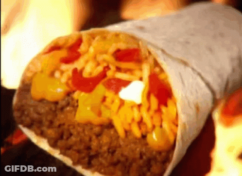 A Burrito Filled With Meat , Cheese , Rice And Peppers On A Table . GIF