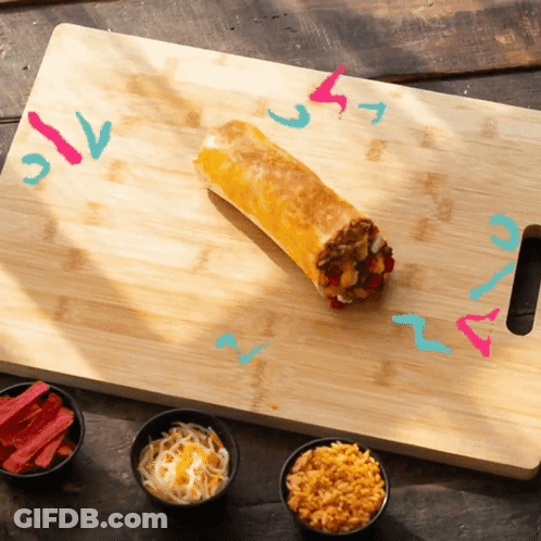 A Burrito Is Sitting On A Cutting Board Next To Bowls Of Various Toppings GIF