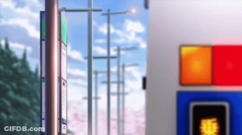 A Bus Stop With Cherry Blossoms In The Background And A Red Light GIF