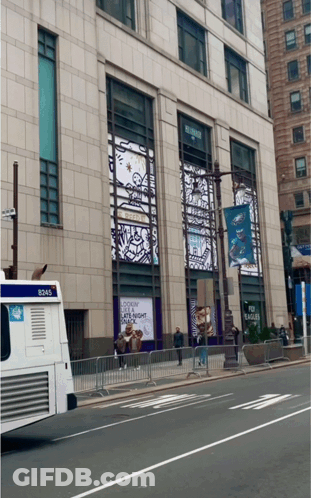 A Bus With The Number 8245 On The Back Is Parked In Front Of A Building GIF