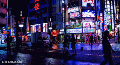 A Busy City Street At Night With A Sign That Says ' Tokyo ' On It GIF