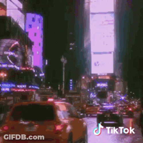 A Busy City Street At Night With A Tik Tok Watermark GIF