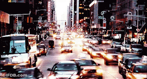 A Busy City Street With A Sign That Says Hi GIF