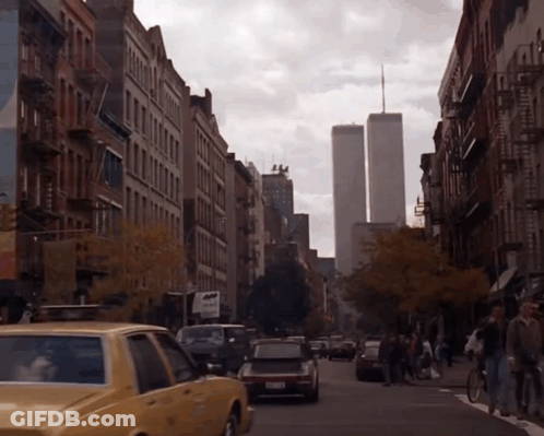 A Busy City Street With A Taxi That Says NYC Taxi On The Side GIF