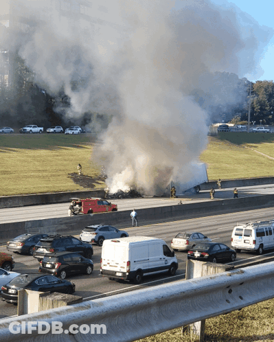 A Busy Highway With Smoke Coming Out Of A Truck That Is On Fire GIF
