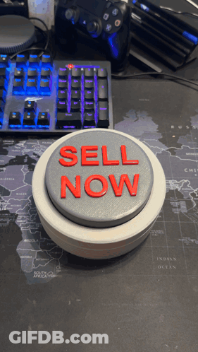 A Button That Says Sell Now Is On A Desk GIF