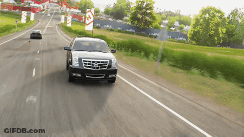 A Cadillac Is Driving Down A Road With A Sign That Says ' A ' On It GIF