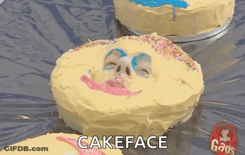 A Cake With A Face Painted On It And The Words Cakeface Written Below It GIF