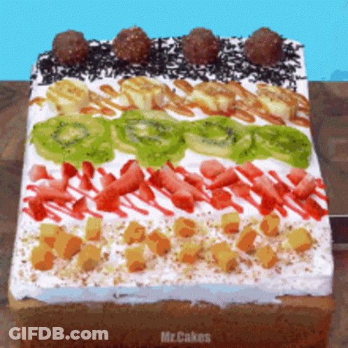 A Cake With Kiwi Bananas Strawberries And Chocolate Sprinkles GIF