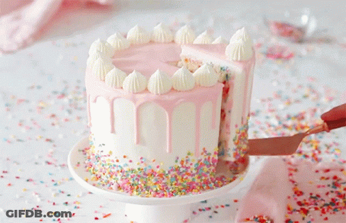 A Cake With Pink Frosting And Sprinkles Is Being Sliced GIF