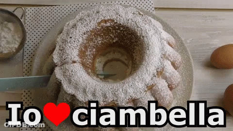 A Cake With Powdered Sugar On It And The Words Io Ciambella Above It GIF