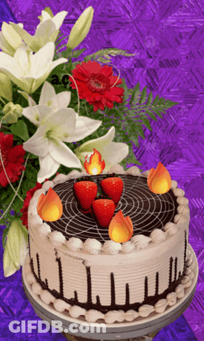 A Cake With Strawberries And Candles On It GIF