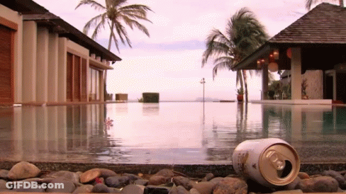 A Can Of Beer Is Laying On The Edge Of A Pool GIF