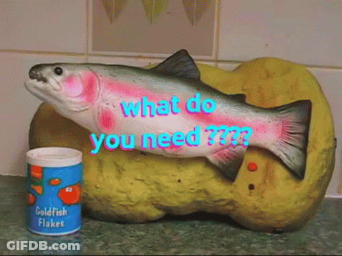 A Can Of Goldfish Flakes Sits Next To A Fish Figurine GIF
