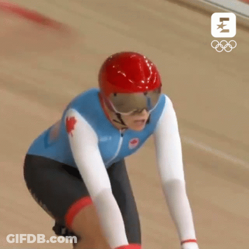 A Canadian Athlete Wearing A Red Helmet And Goggles Is Riding A Bike GIF
