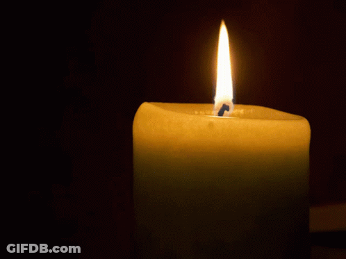 A Candle Is Lit Up In The Dark And Has A Blue Candle Sticking Out Of It GIF