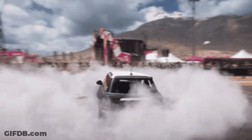 A Car Is Doing A Burnout On A Race Track GIF