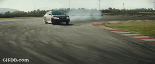 A Car Is Drifting On A Track And Smoke Is Coming Out Of The Tires GIF