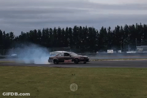 A Car Is Drifting On A Track With Smoke Coming Out Of The Tires .. GIF