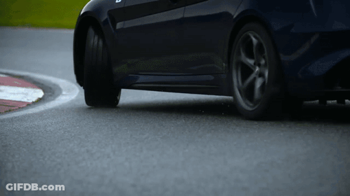 A Car Is Driving Around A Curve On A Race Track GIF