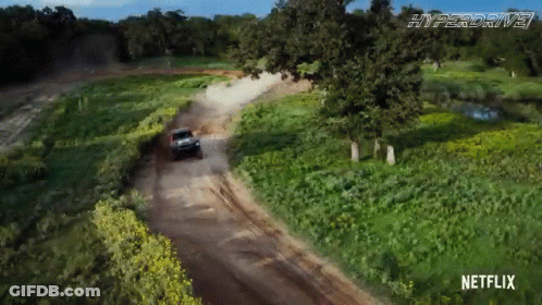 A Car Is Driving Down A Dirt Road With Netflix On The Bottom GIF