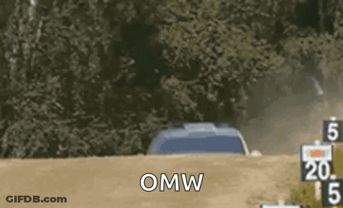 A Car Is Driving Down A Dirt Road With The Words `` Omw '' Written On It . GIF