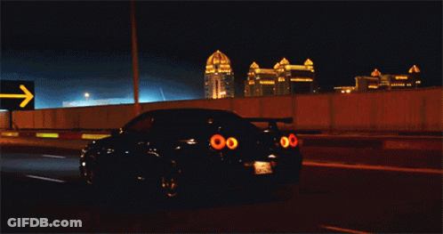 A Car Is Driving Down A Highway At Night With A Sign Behind It That Says ' Khara ' GIF