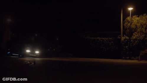A Car Is Driving Down A Road At Night GIF