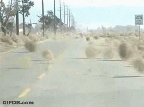 A Car Is Driving Down A Road With A Lot Of Dust Coming Out Of The Windshield . GIF