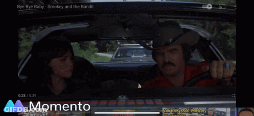 A Car Is Driving Down A Road With A Momento Logo In The Background GIF