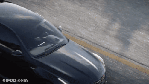 A Car Is Driving Down A Road With A Yellow Line In The Middle GIF