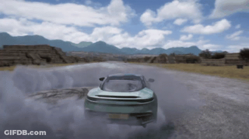A Car Is Driving Down A Road With Mountains In The Background And Smoke Coming Out Of It GIF