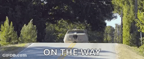 A Car Is Driving Down A Road With The Words `` On The Way '' Written On The Bottom . GIF