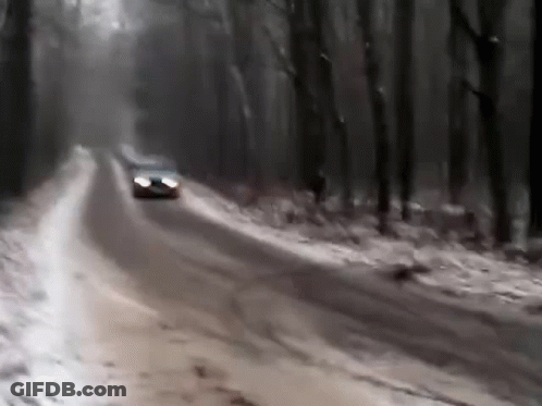 A Car Is Driving Down A Snow Covered Road GIF