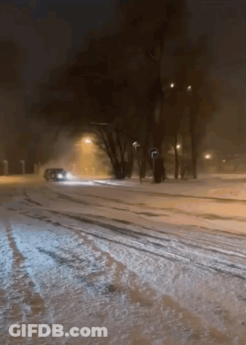 A Car Is Driving Down A Snow Covered Street GIF
