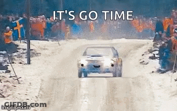 A Car Is Driving Down A Snowy Road With A Crowd Watching . GIF