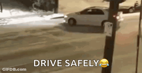 A Car Is Driving Down A Snowy Street With The Words `` Drive Safely '' Written On The Bottom . GIF