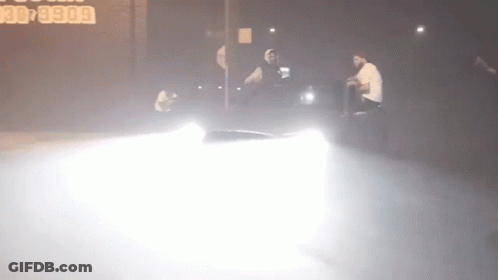 A Car Is Driving Down A Street At Night With A Sign In The Background That Says 30 5900 GIF