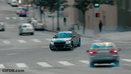 A Car Is Driving Down A Street With A Red Light GIF