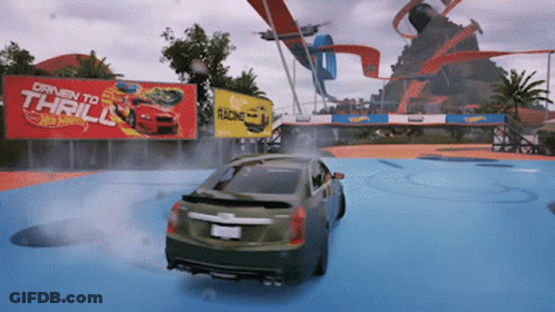 A Car Is Driving In Front Of A Hot Wheels Sign GIF